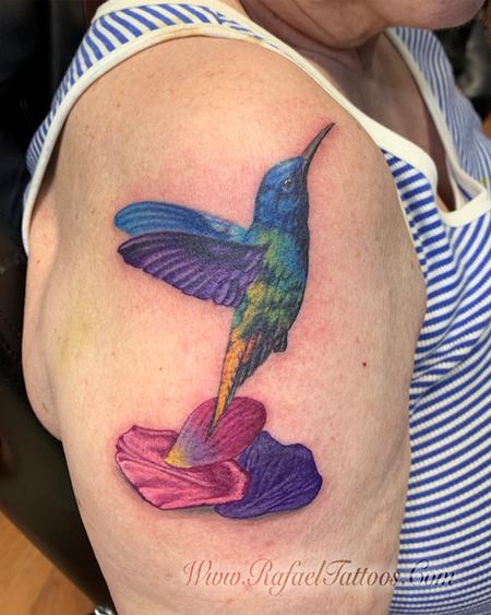 Rafael Marte - Realistic hummingbird with flower petals tattoo on aged skin